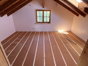 Earlier phase of flooring work showing battens installed over the subfloor, ready for insulation or further layering.