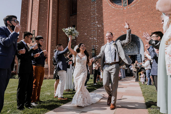 Joyful newlyweds exit church as guests cheer