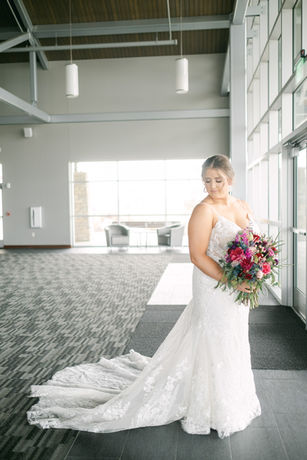 Bride in white wedding dress holding a colorful bouquet