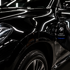 Hand in black glove holding FF paint protection bottle by car