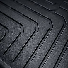 Clean black rubber car floor mat with deep ridges.