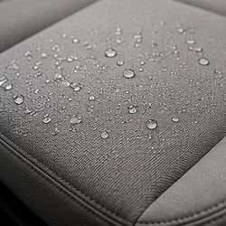 Water droplets on a clean, grey fabric car seat.