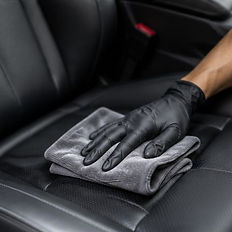 Professional hand wiping leather car seat for interior detail