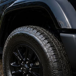 Close-up of a clean black off-road tire and wheel well.