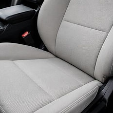 Clean grey fabric car seat after shampoo service.