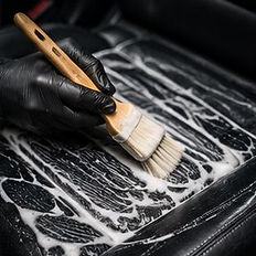Professional leather cleaning and conditioning on a car seat.
