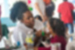 Adult woman face painting adolescent girl's face