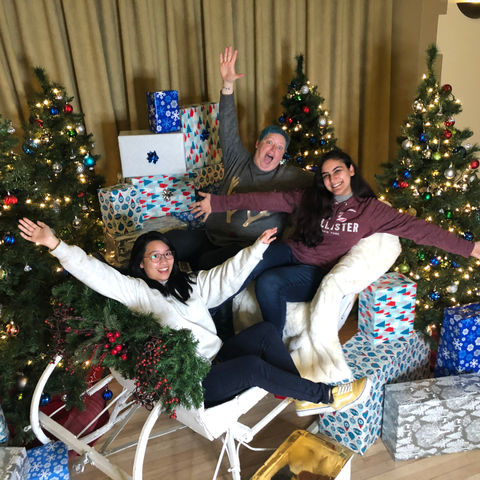Three women – colleagues and friends – take a Christmas photo together.