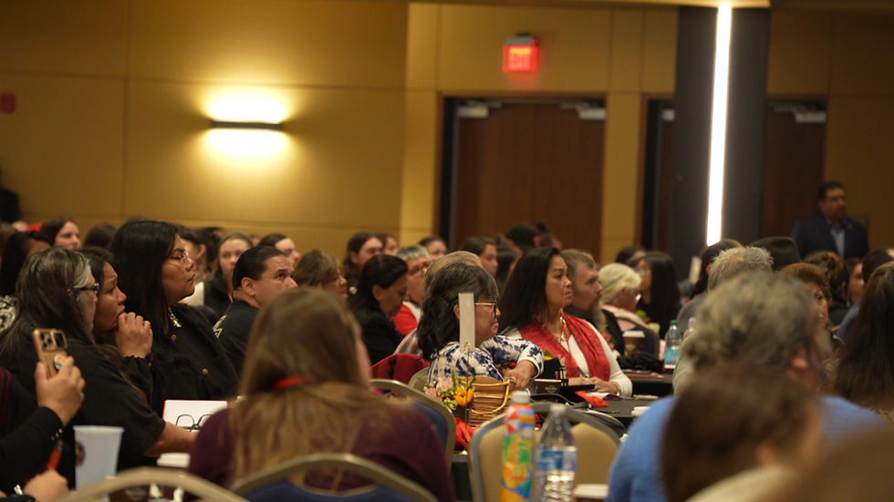 A crowd listening intently to a speaker in a conference hall.
