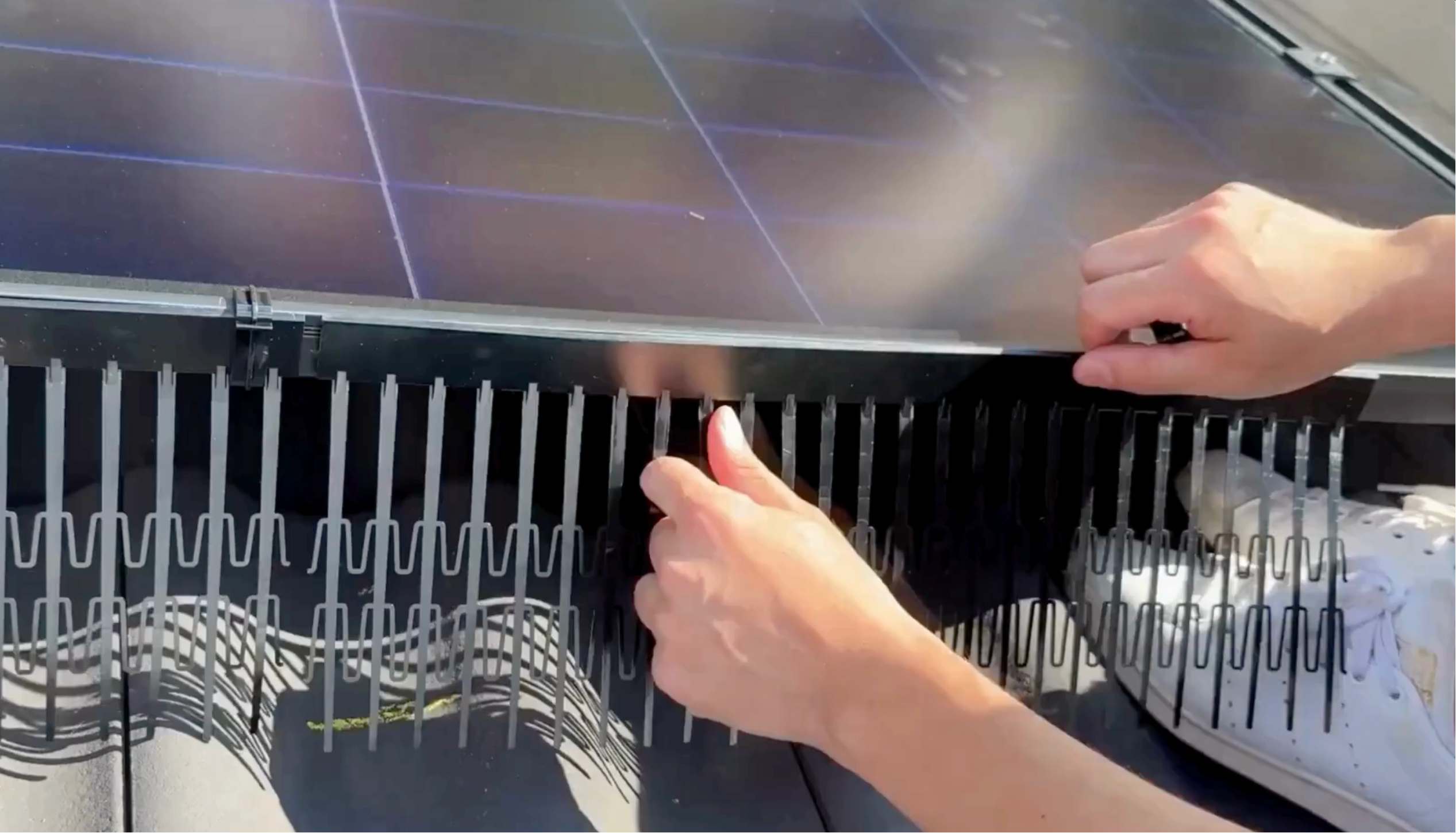 Hands joining Perimeter Segments under the module edge without tools, no drilling solar panel frame — PV Protector®