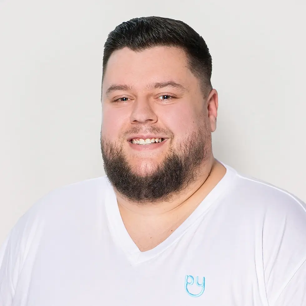 Junger männlicher Pflegehelfer vom ambulaten Pflegedienst halpy grinst freundlich.