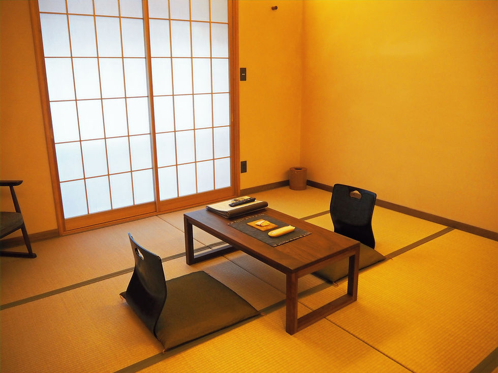 Guest room showcasing tatami mats covering the floor, low tables, and sliding doors. Ryokan Ohnuma in Miyagi, Tricolage