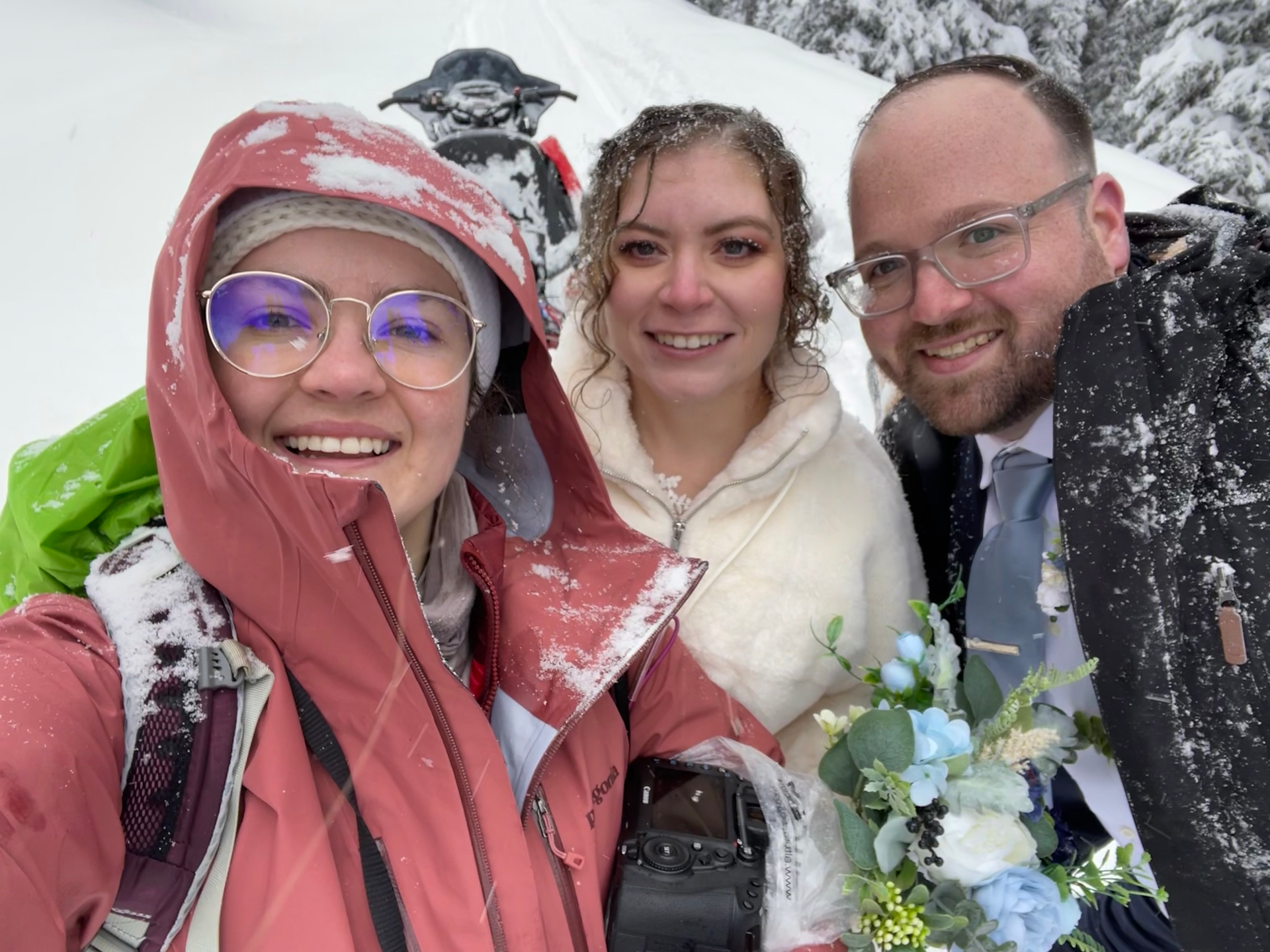 Snowmobile elopement photographer and her couple eloping in the snow