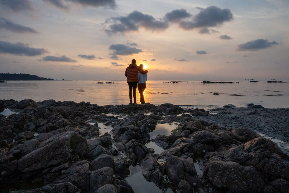couple watching sunset on leree beach