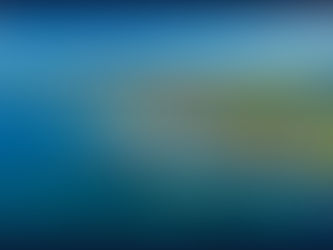 Aerial view of a coastal town in Cyprus with a marina and yachts; green fields and hills in the background. Clear blue sky and sea create a serene mood.