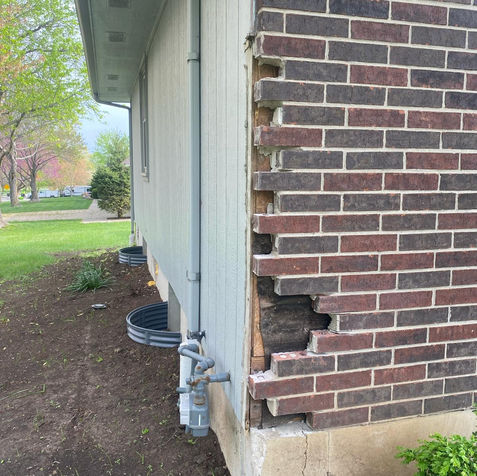 Damaged brick wall needing repair