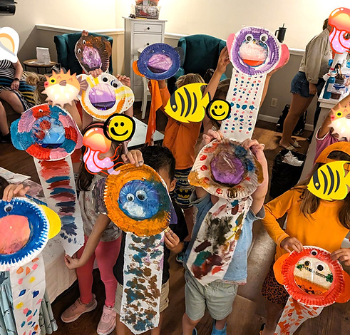 Group of kids holding up their arts and crafts project they did at The Wonder Club