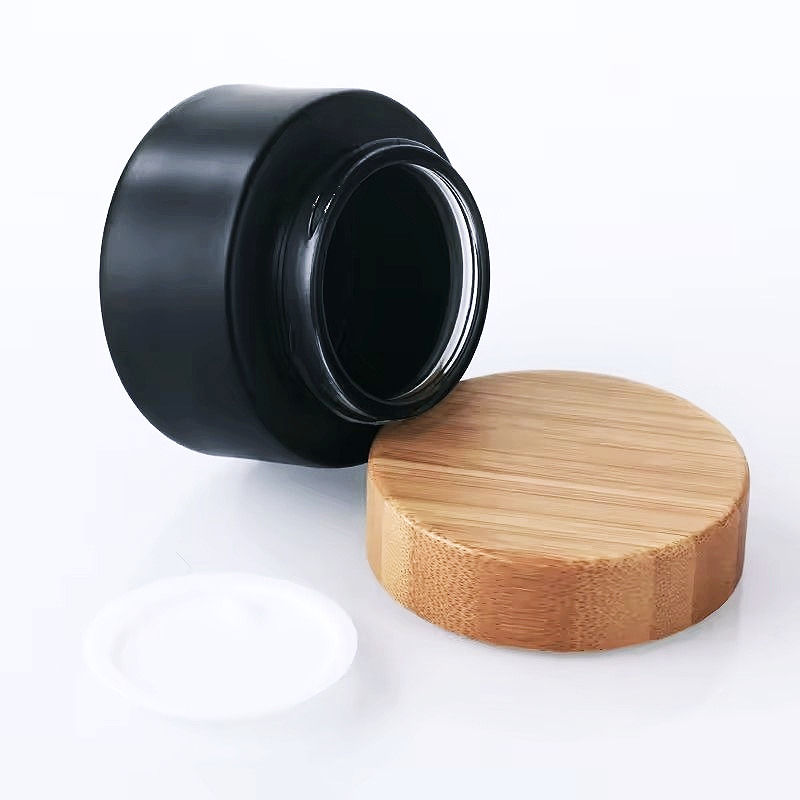 Pot en verre noir écoresponsable pour crèmes et baumes cosmétiques avec son couvercle en bambou et son opercule blanc