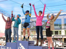 A cyclist standing on the podium in 3rd place at a mountain bike race