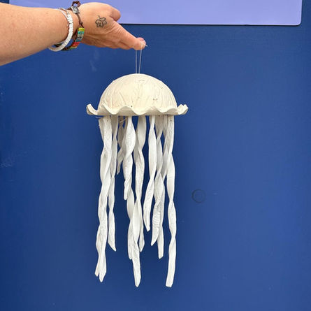 A hand holds a ceramic jellyfish