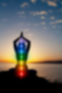 Silhouette of woman sits in a lotus pose on beach sunset view, glowing seven all chakra. K