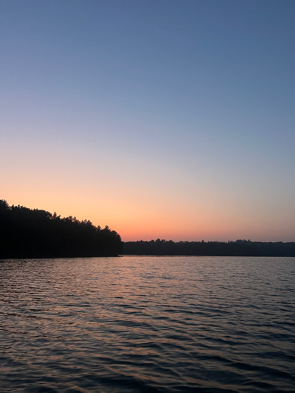 Tranquil lake at dusk with a sunset sky