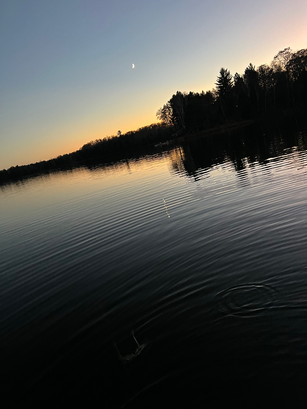Fishing lure in calm lake water at sunset
