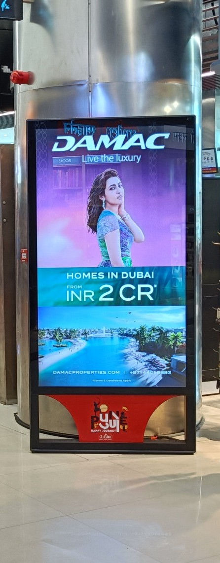 Digital airport advertising screen displaying promotional campaign inside terminal