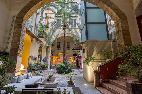 Cortile interno con vegetazione e struttura in pietra. Fotobnb (B&B). Ospiti di lusso.