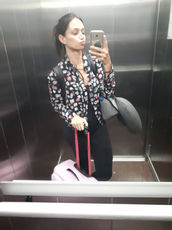 Mulher em elevador com mala, selfie.