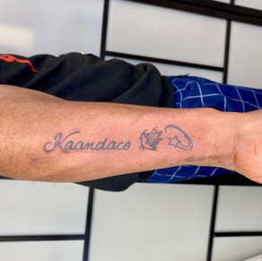 script tattoo. arm tattoo with black ink