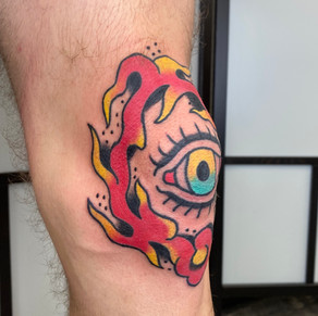 Traditional Tattoo on the knee. Color tattoo with an eye in the center.
