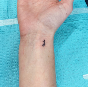 Mini lowercase j tattoo on the wrist
