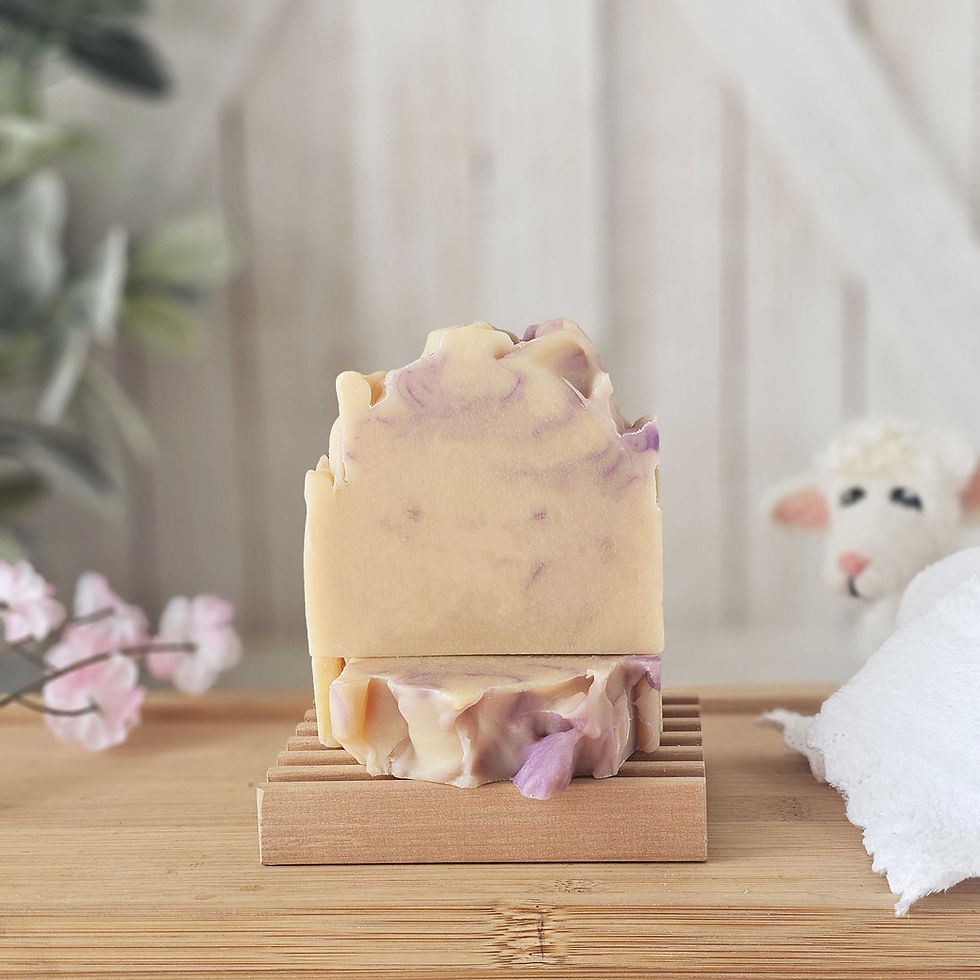 Two bars of soap unwrapped. Flowers off to the left