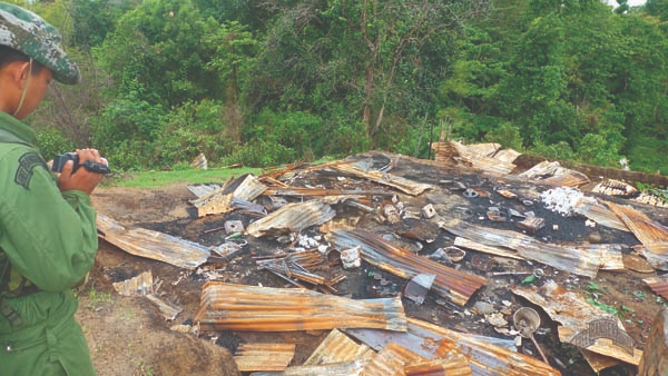 A Ranger videos the remains of a villager’s house, burned to the ground by Burma Army troops