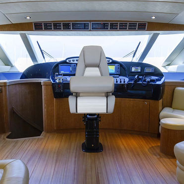A beige and white besenzoni Helm seat P 007 Eclypse in the cockpit of a luxury yacht