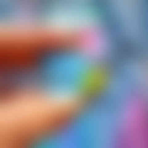 Close-up of blue tit wooden brooch made from sustainable walnut veneered MDF with glossy details