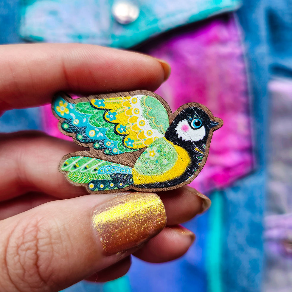 Close-up of yellow tit wooden brooch on maple-veneered MDF with glossy details on feathers