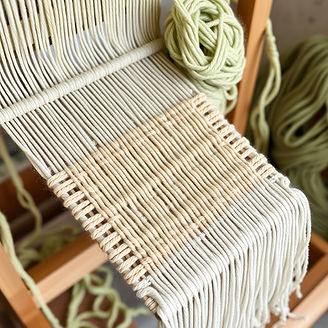 Pale green and tan woven yarn on a loom.jpg