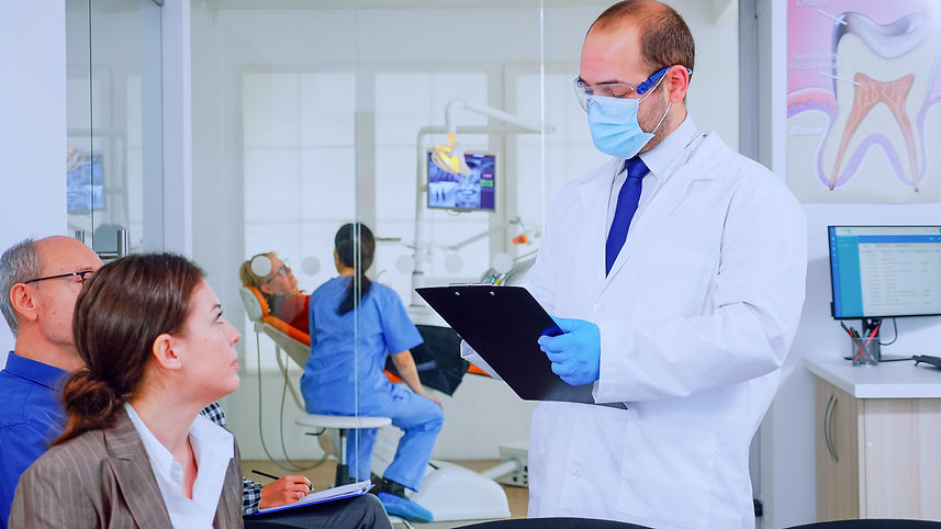 doctor-taking-notes-clipboard-about-patient-dental-problems-sitting-chair-waiting-room-sto