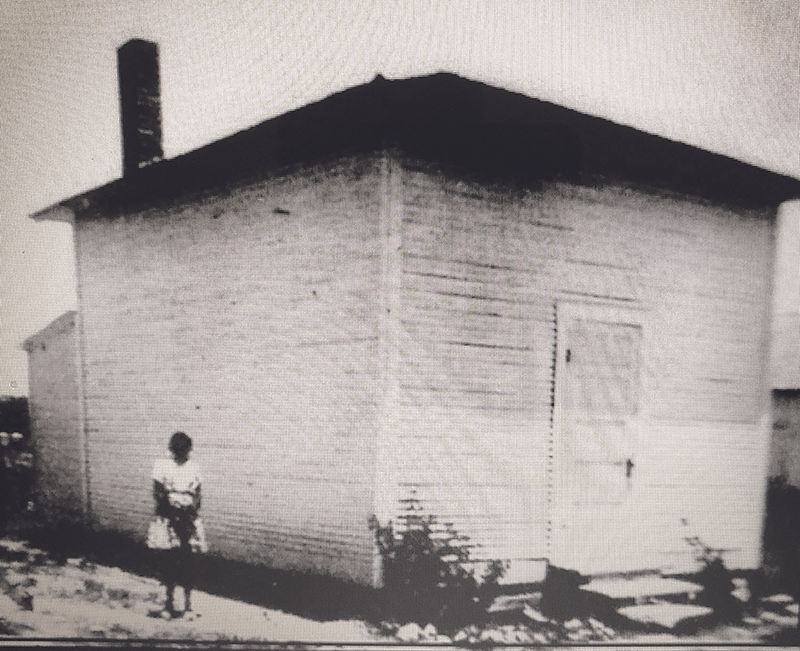 A young girl in front of the free school erected between 1870-80
