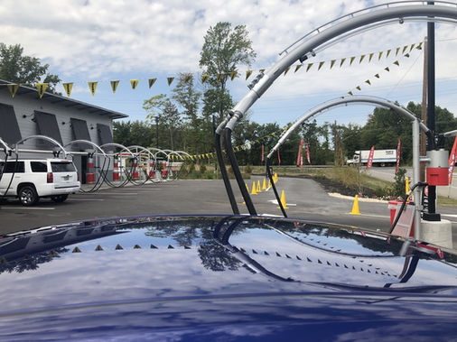 Car wash entrance with arches and a white SUV Showroom Shine Car Wash