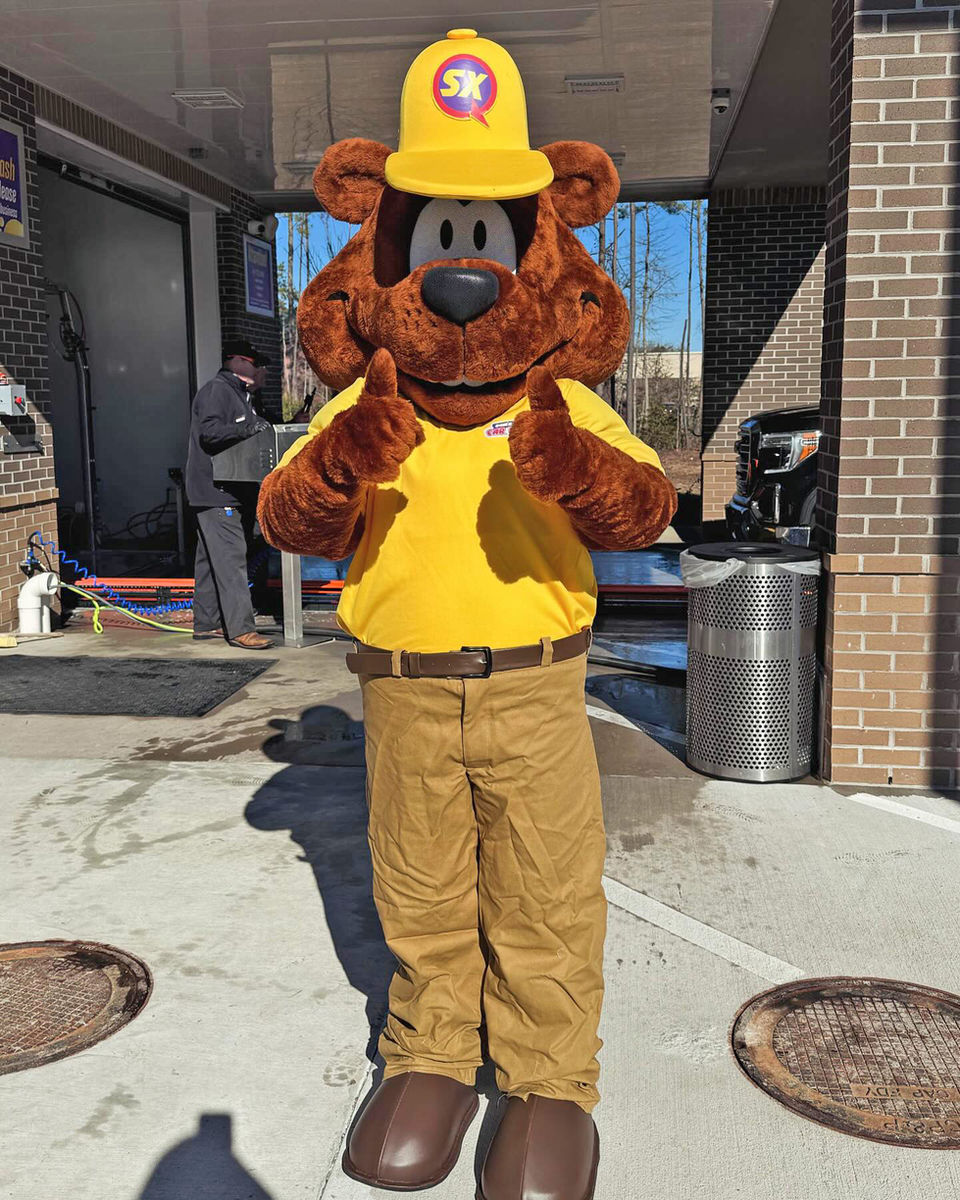 Costumed Sam The Bear giving thumbs up at Sam’s Xpress Car Wash location