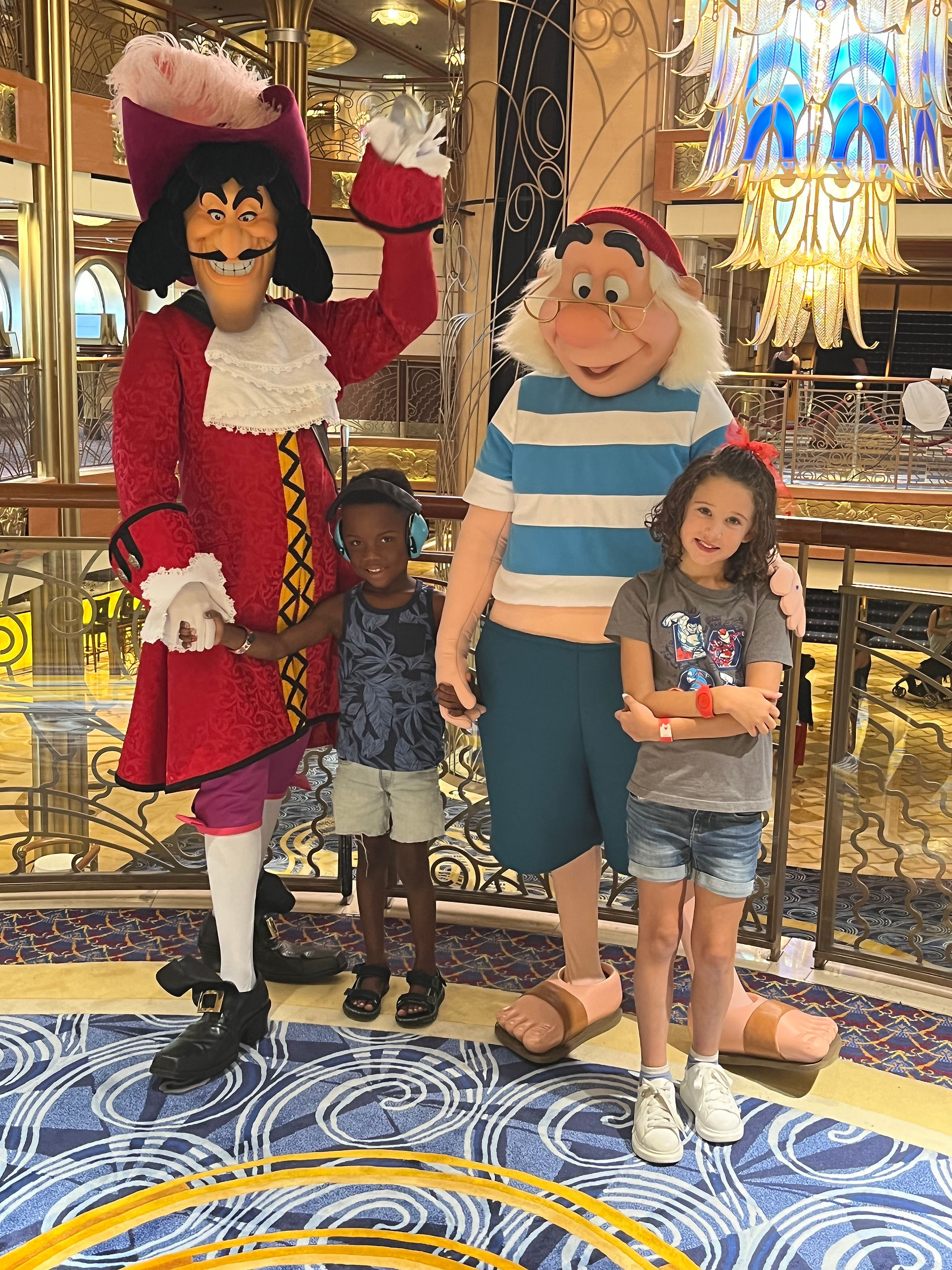 Captain Hook and Mr. Smee meeting guests during Pirate Night character meet and greets aboard a Disney Cruise ship.