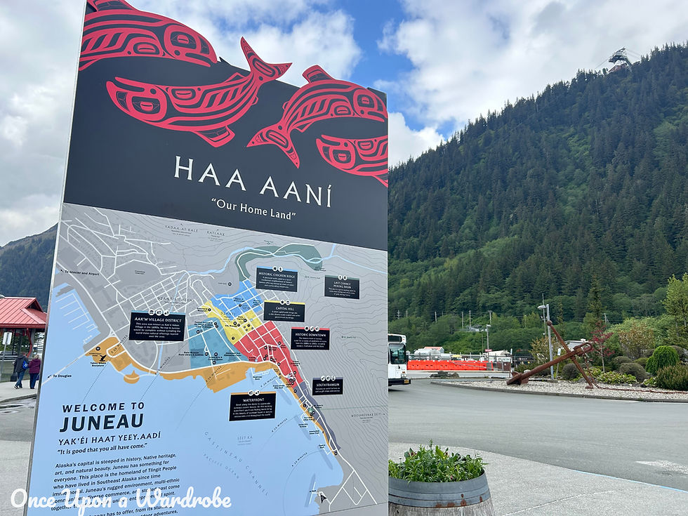 Large “Haa Aaní – Our Homeland” welcome sign in Juneau, Alaska, with a detailed city map and scenic mountain backdrop.