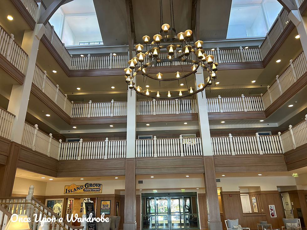 Grand lobby interior at Disney’s Vero Beach Resort featuring a large nautical chandelier, multi-level balconies, and bright coastal design details