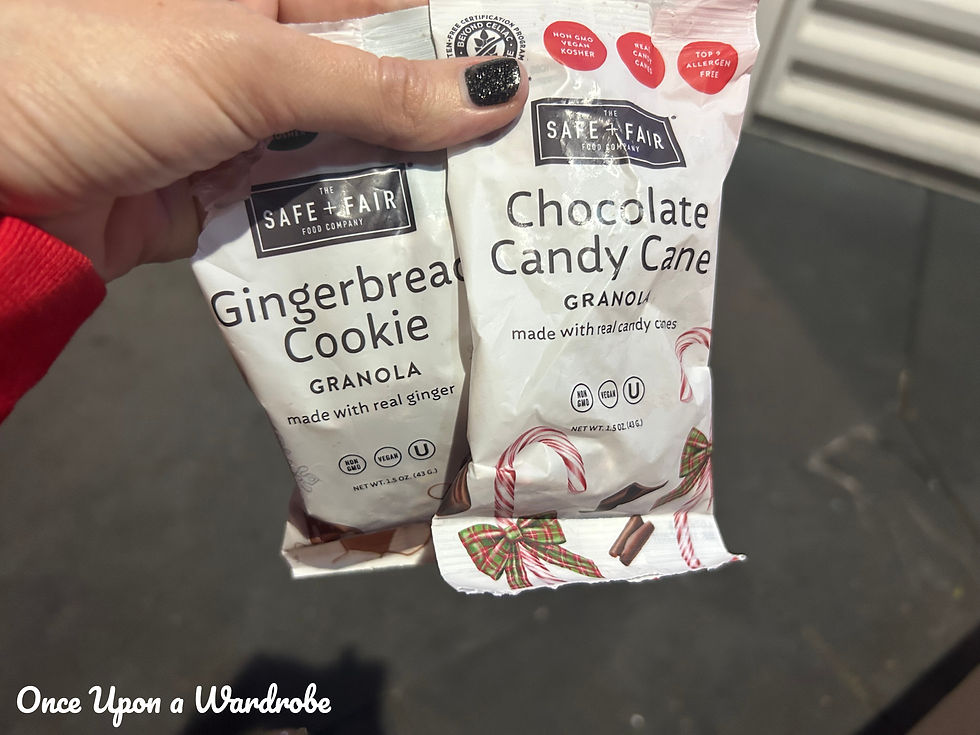 Hand holding two holiday-flavored Safe + Fair granola snack bags—Gingerbread Cookie and Chocolate Candy Cane—available during Mickey’s Very Merry Christmas Party.