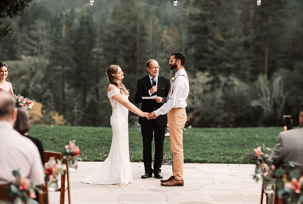 A wedding couple holding hands during their outdoor ceremony overlooking a forest background for their Wedding in Tahoe