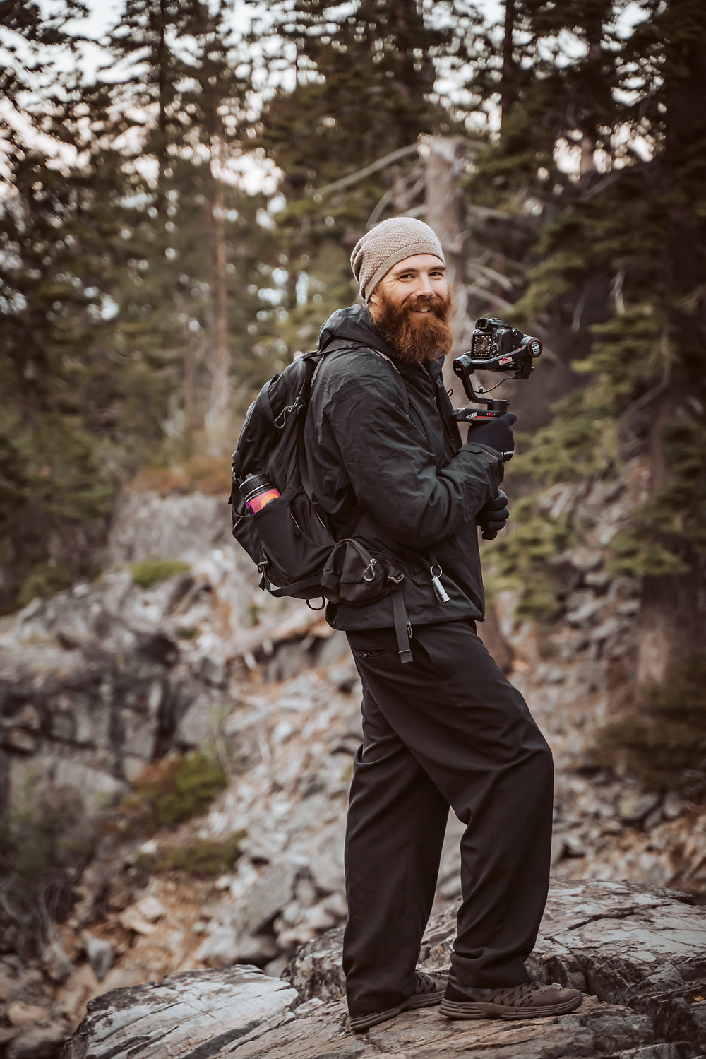 A elopement videographer hiking with his camera gear in the mountains