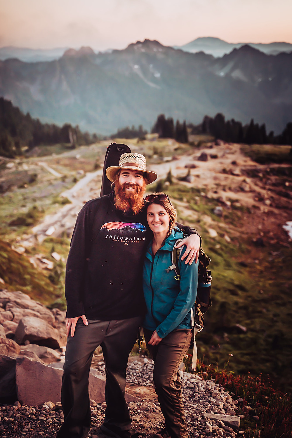 A elopement photographer and videographer team hiking in the mountains for an adventure wedding